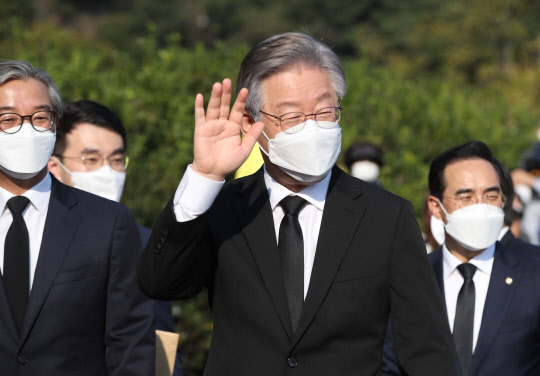 더불어민주당 대선 후보인 이재명 경기도지사가 22일 오후 경남 김해시 진영읍 봉하마을 노무현 전 대통령 묘역 참배 후 권양숙 여사 예방에 앞서 지지자에게 손 인사하고 있다. <김해=연합뉴스>